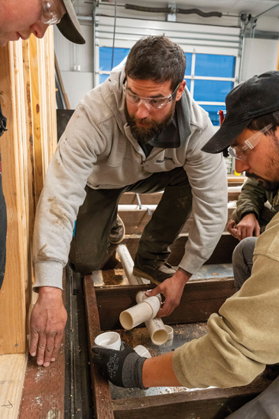 Caleb Herrera/KCC photo Plumbing students at Klamath Community College learn the right techniques for aligning pipes in a tiny RV-style home being built on the campus. The home will be auctioned off at the annual  Klamath Basin Homebuilders Association event Jan. 9 at the Klamath County Fairgrounds.